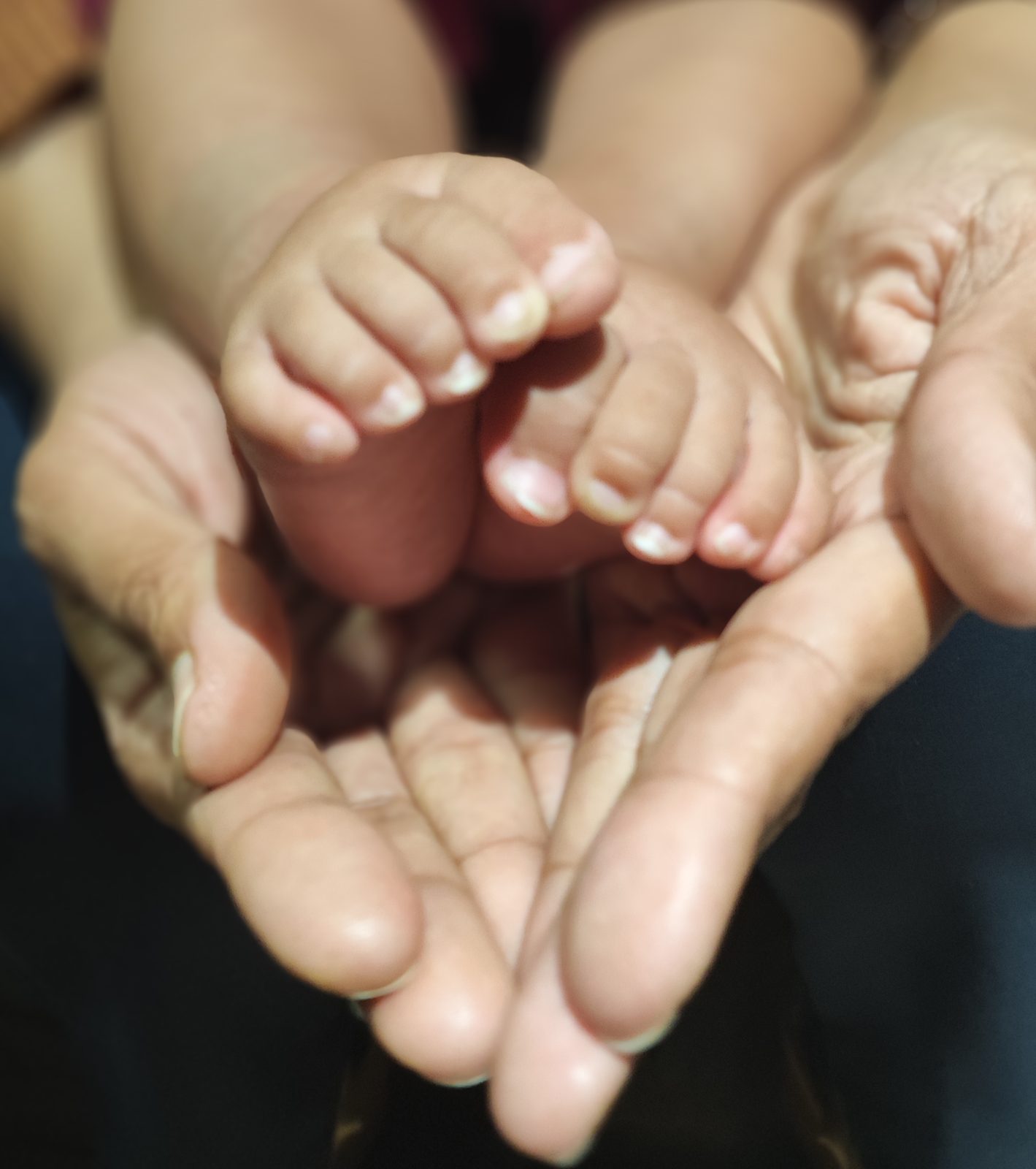 A child's hand held in a caring hand